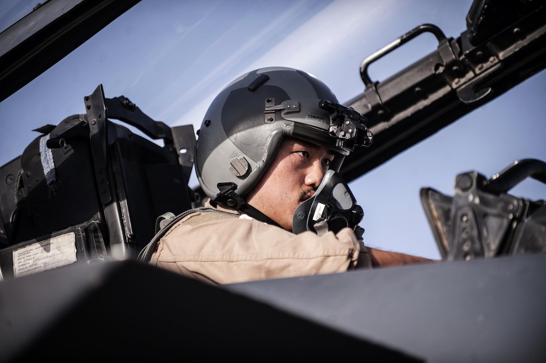 A pilot sits in the cockpit of an aircraft.