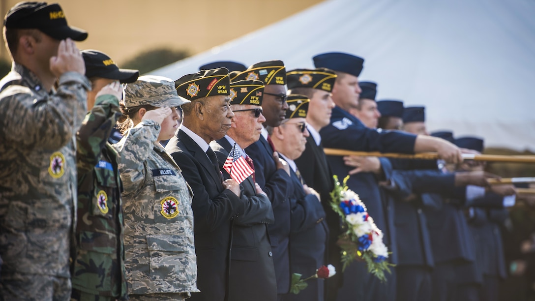 Airmen and veterans salute during a Veterans Day ceremony.