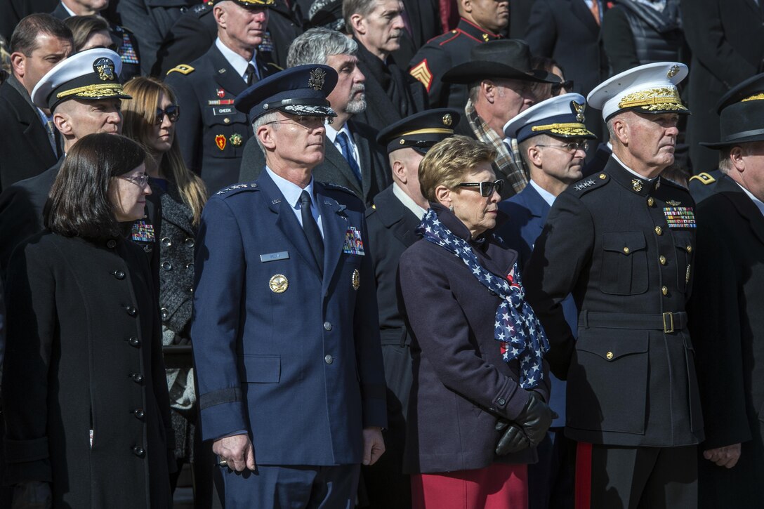 Air Force Gen. Paul Selva and Marine Corps Gen. Joe Dunford and their wives stand during a ceremony.