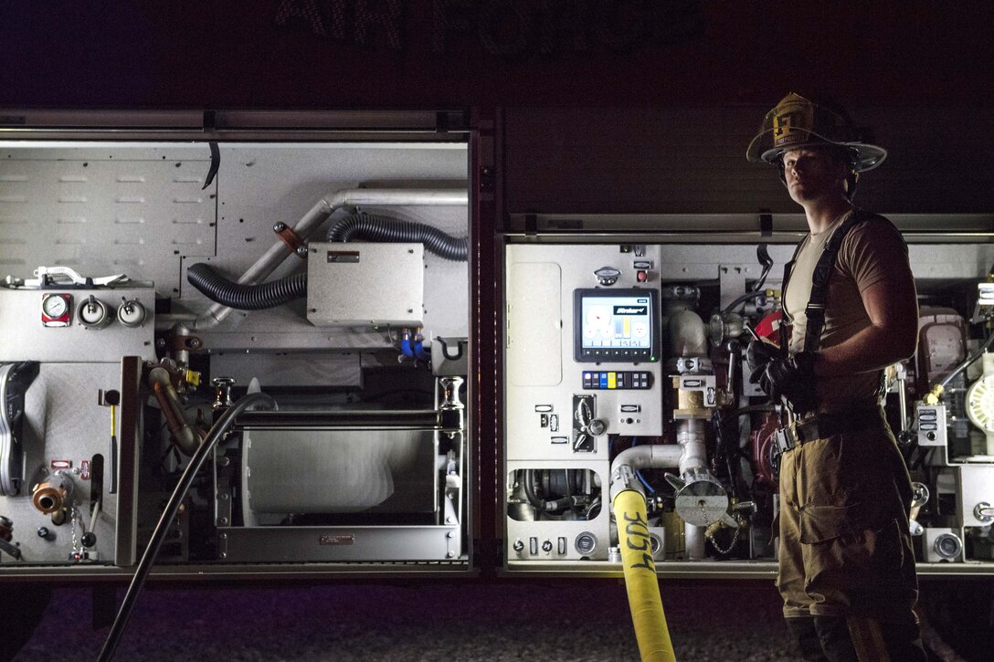 Airman 1st Class Jacob Molden waits for a signal before shutting the water off during annual nighttime firefighting training.