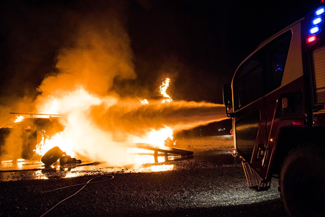 Water shoots from a firetruck turret during annual nighttime firefighting training at Moody Air Force Base.