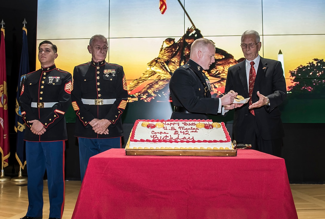 Maj. Alan Thompson hands John Wolfe a piece of cake during the 242nd Marine Corps birthday celebration at DSCC