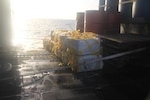Stacks of seized cocaine sit on the deck of USS Zephyr.