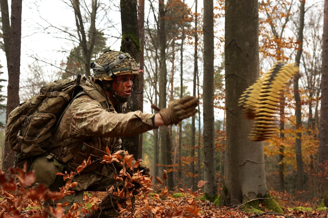 British army Lance Cpl. Thomas Bewlay throws ammunition to fellow soldiers while conducting a reconnaissance mission during exercise Allied Spirit VII at the Army’s Joint Multinational Readiness Center in Hohenfels, Germany.