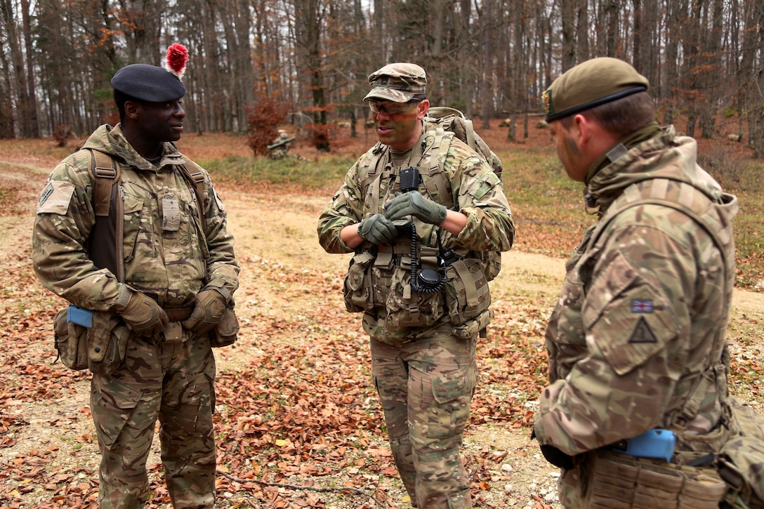 U.S. Army Sgt. 1st Class Derek Castro, center, discusses mission tactics with British army Lance Cpl. Ishmael Griffiths and Cpl. Jake Ward during exercise Allied Spirit VII.