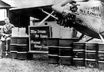 Charles Lindbergh at a St. Louis airfield after his Atlantic crossing, promoting the 35th Division, Missouri National Guard. The barrels and two small cans contained fuel for his transatlantic flight.