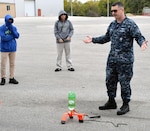 Petty Officer 1st Class Ian MacKay, Navy Recruiting District San Antonio nuclear field coordinator for South Texas, explains to middle school students about an experiment with a plastic bottle rocket at the 8th Annual San Antonio Hispanic Chamber of Commerce CORE4 STEM Expo Nov. 8 at the Freeman Expo Hall.