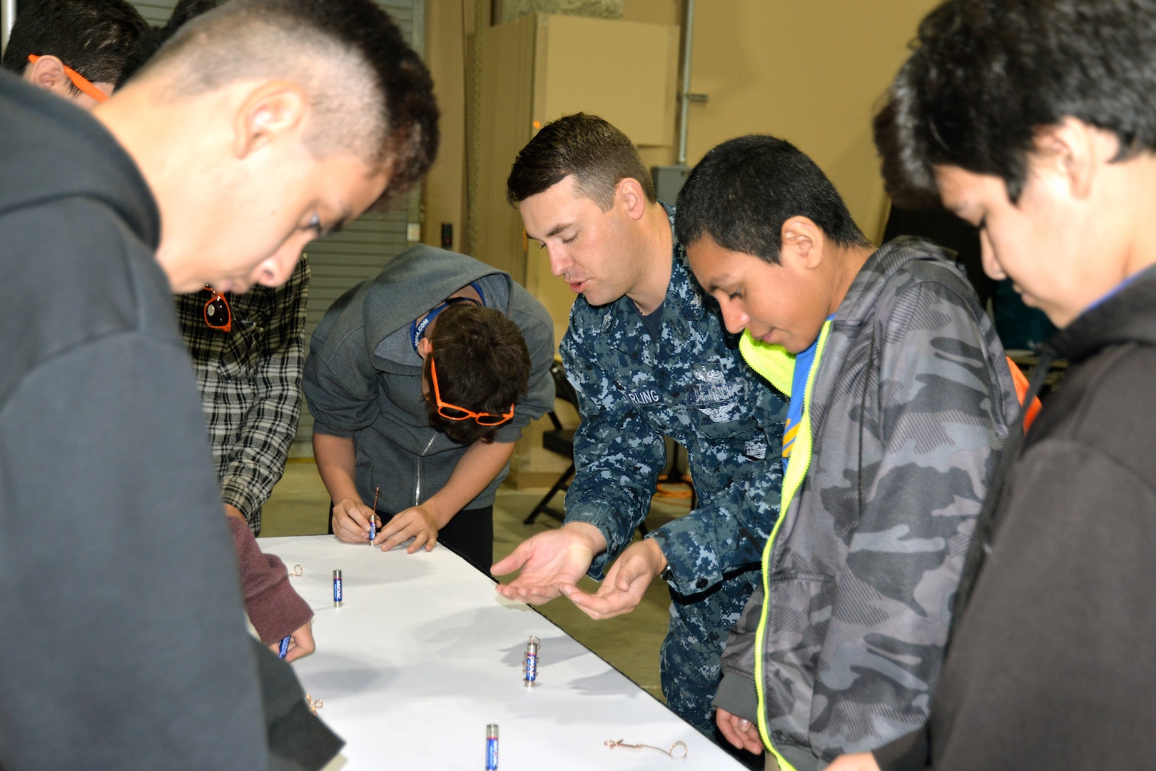 Petty Officer 1st Class Ian MacKay, Navy Recruiting District San Antonio nuclear field coordinator for South Texas, explains to middle school students about an experiment with a plastic bottle rocket at the 8th Annual San Antonio Hispanic Chamber of Commerce CORE4 STEM Expo Nov. 8 at the Freeman Expo Hall.