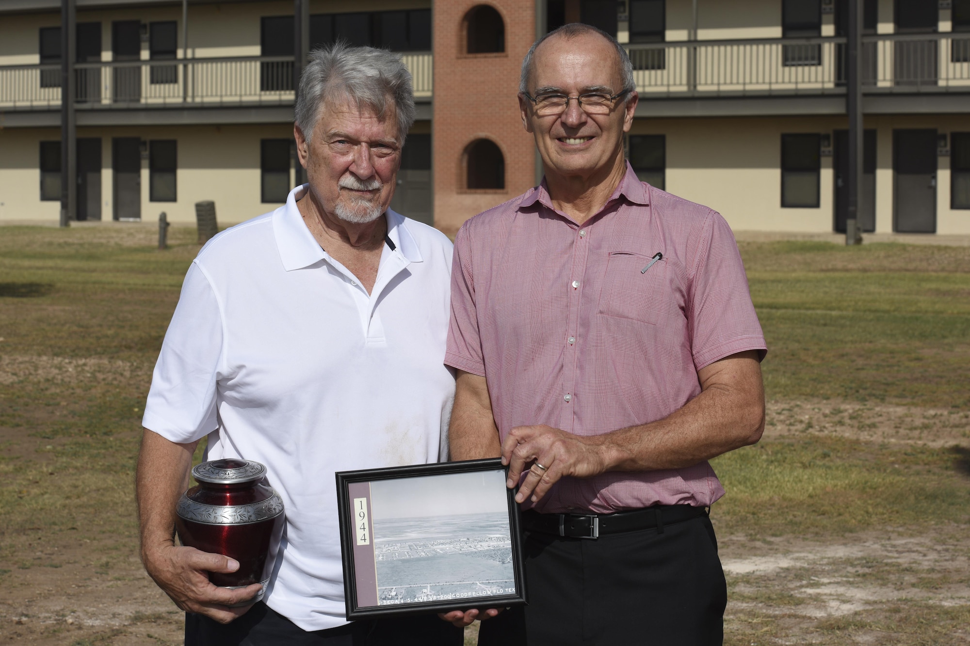 Ron Chichon poses with John Garrett, 17th Training Wing historian, after spreading his mother’s ashes at Goodfellow Air Force Base, Texas, Nov. 6, 2017. Garrett brought a photo of Goodfellow from 1944 to show what the base was like when Ron’s parents were stationed there.
