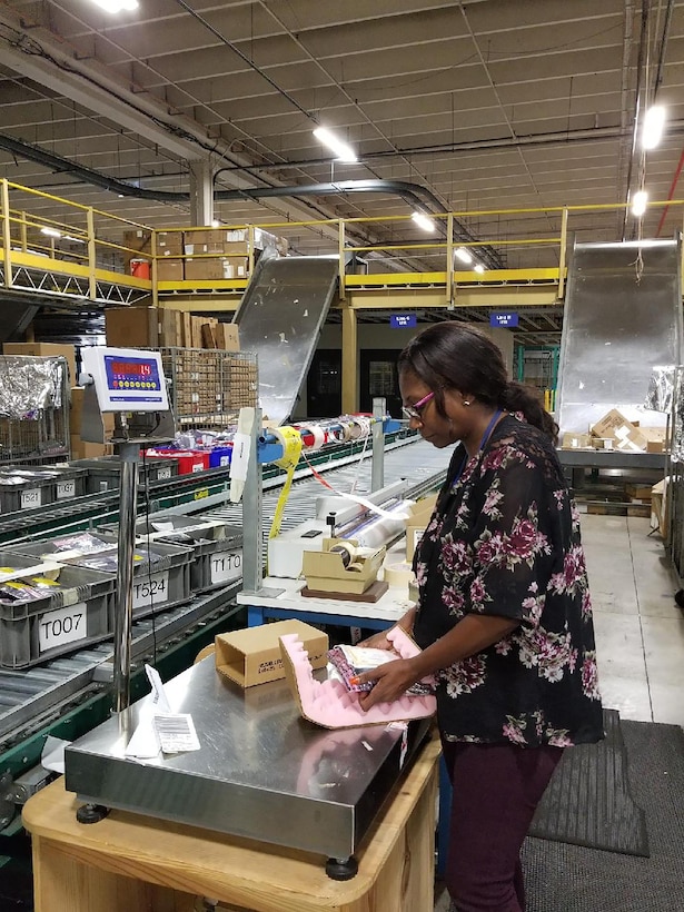 Packer Christie Williams applies protective packaging to preserve the integrity of the item.
