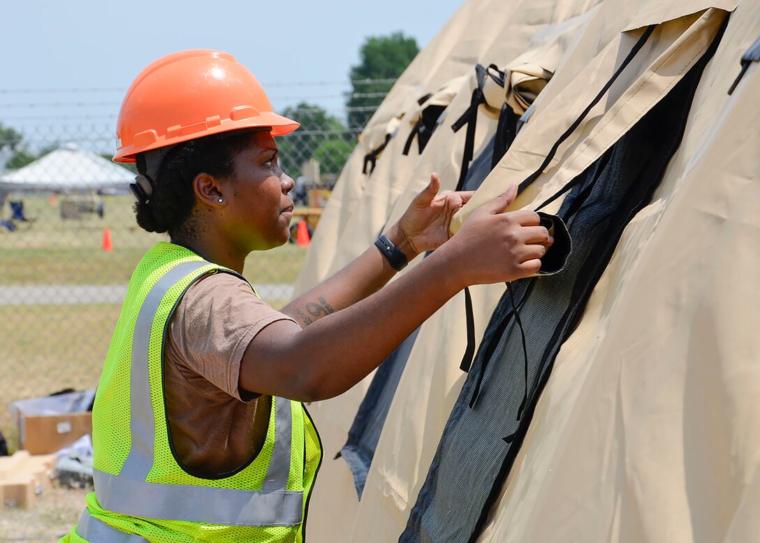 Navy Petty Officer 1st Class Annalisa Brown erects a portable shelter, a standard element of one of DLA Disposition Services’ four Expeditionary Site Sets pre-staged on three continents for quick use during a contingency operation or disaster response.