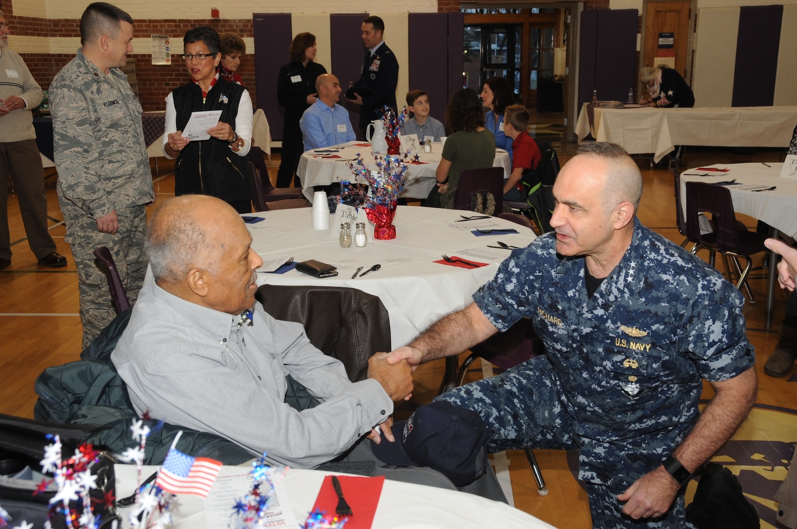U.S. Navy Vice Adm. Charles Richard, deputy commander of U.S. Strategic Command (USSTRATCOM), speaks with a veteran before the 2017 Bellevue Veterans Day Parade in Bellevue, Neb., Nov. 11, 2017. Senior leaders from USSTRATCOM and the 55th Wing participated in several Veterans Day events throughout the Omaha area to honor the service and sacrifice of American veterans and their families.