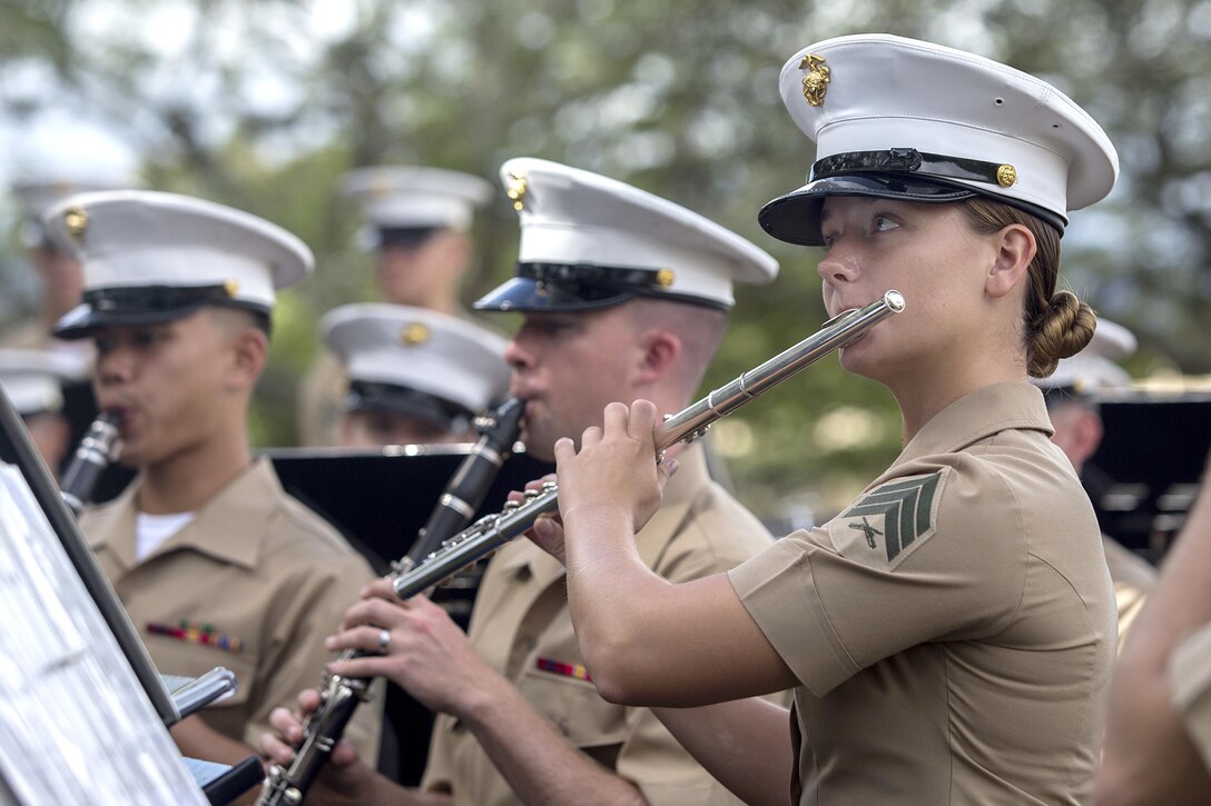 Marines play instruments while seated.