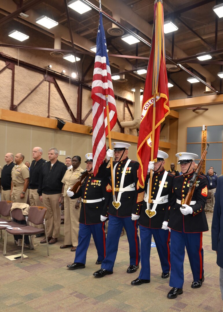 Four Marines dressed in their blues parade the colors.