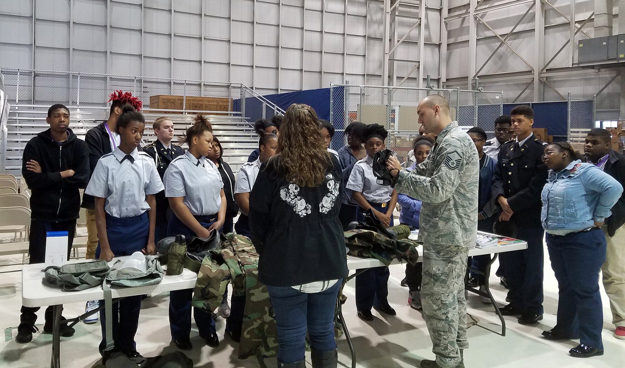Master Sgt. Brandon Ashcraft, 445th Civil Engineer Squadron wing emergency manager, demonstrates to students from Thurgood Marshall and Meadowdale High Schools how to don a gas mask during the Dayton public schools outreach event the 445th Airlift Wing hosted Oct. 20, 2017.