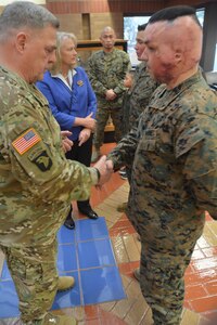 U.S. Army Chief of Staff Gen. Mark A. Milley presents his military coin to Marine Lance Corp. Mathew Maddux while visiting Brooke Army Medical Center in honor of Veterans Day Nov. 11, 2017.