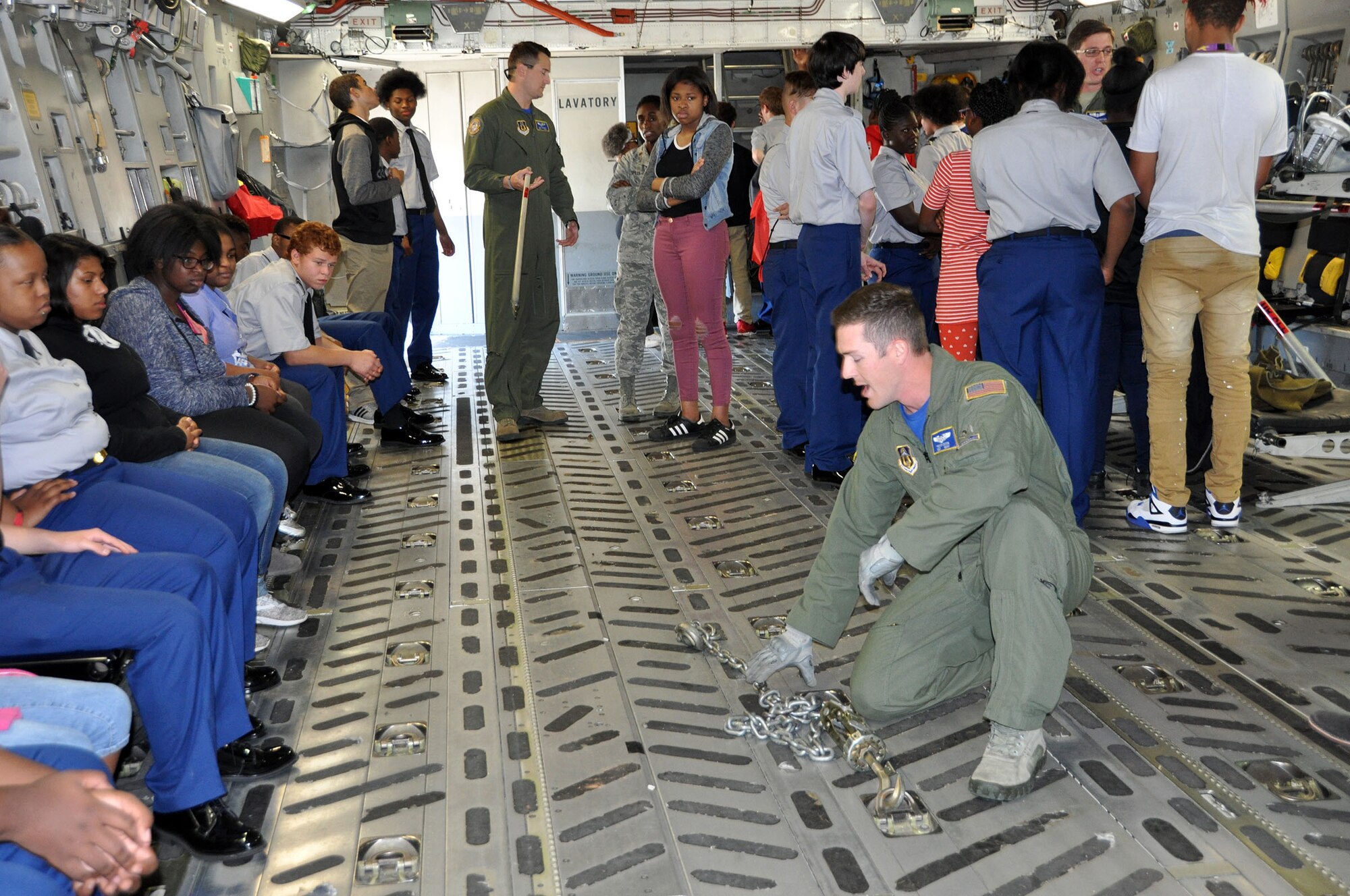 Tech. Sgt. Trevor Dixon, 89th Airlift Squadron loadmaster, demonstrates to a group of students from Thurgood Marshall and Meadowdale High Schools how chains are used to tie down various types of cargo to the floor of a C-17 Globemaster III during the Dayton public schools outreach event the 445th Airlift Wing hosted Oct. 20, 2017