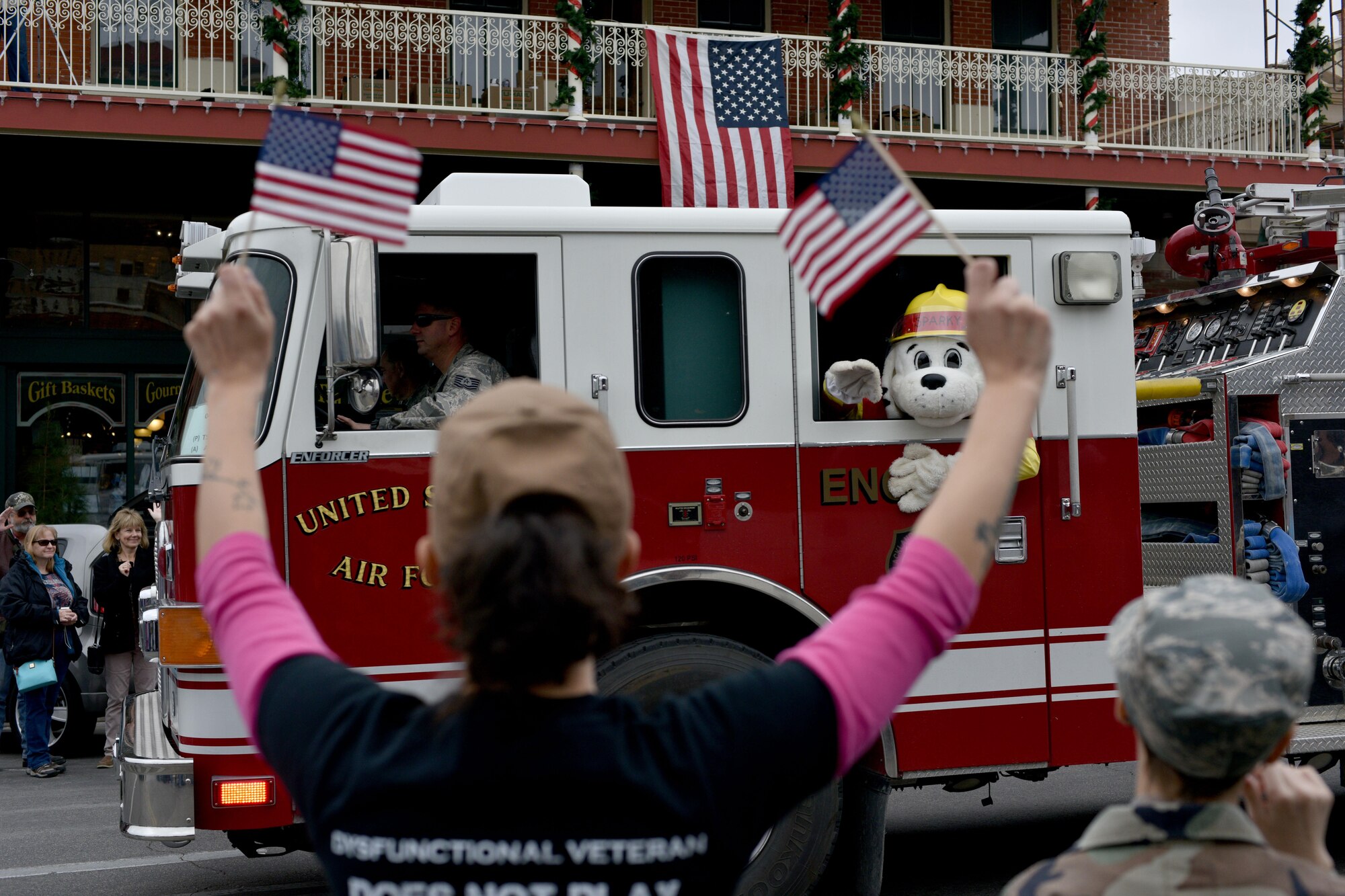 Parade participants wave flags as a Goodfellow Air Force Base fire truck drives by during the Veteran’s Day parade in San Angelo, Texas, Nov. 11, 2017. The city hosted its annual parade in honor of those serving and those who have served the country.