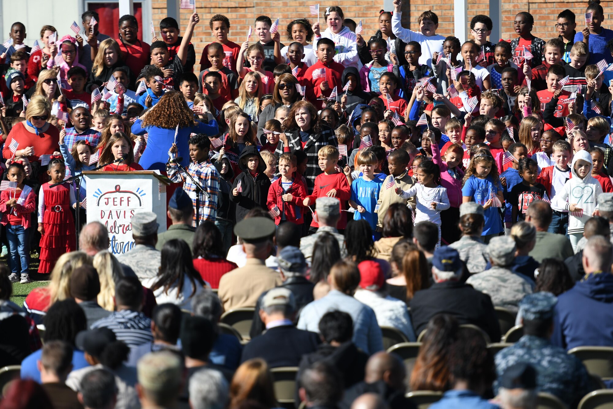 Students at Jeff Davis Elementary School sing patriotic songs during a Veterans Day celebration Nov. 10, 2017, in Biloxi, Mississippi. During the event, students also recited the Pledge of Allegiance. Keesler Air Force Base leadership, honor guardsmen and base personnel attended the event. (U.S. Air Force photo by Kemberly Groue)