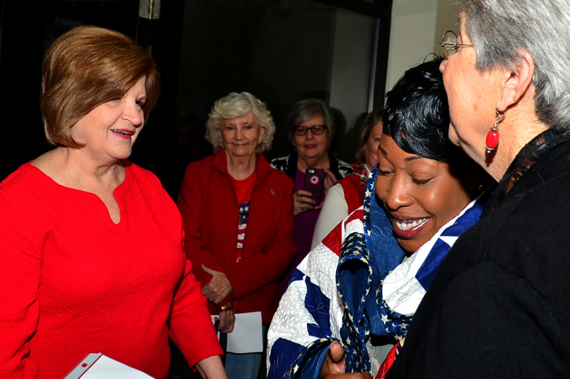 U.S. Air Force Tech. Sgt. Portia Wyatt, 20th Security Force Squadron first sergeant, is embraced by Quilts of Valor Foundation (QOVF) members during a QOVF event at Shaw Air Force Base, South Carolina, Nov. 9, 2017.