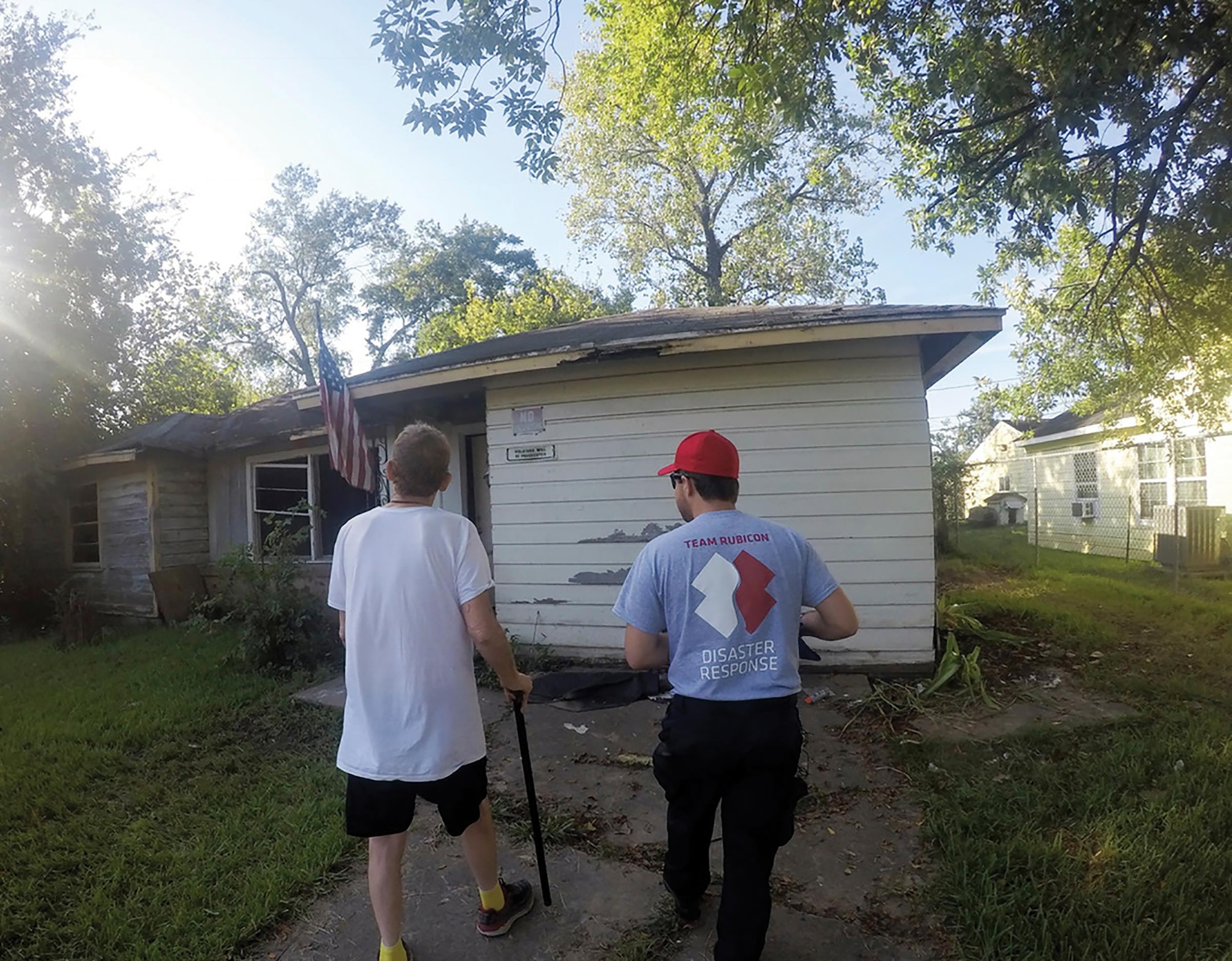 Tech. Sgt. Cody Smeltzer, 445th Aerospace Medicine Squadron, walks with Bruce, a disabled Vietnam veteran, to assess his home that was damaged during Hurricane Harvey