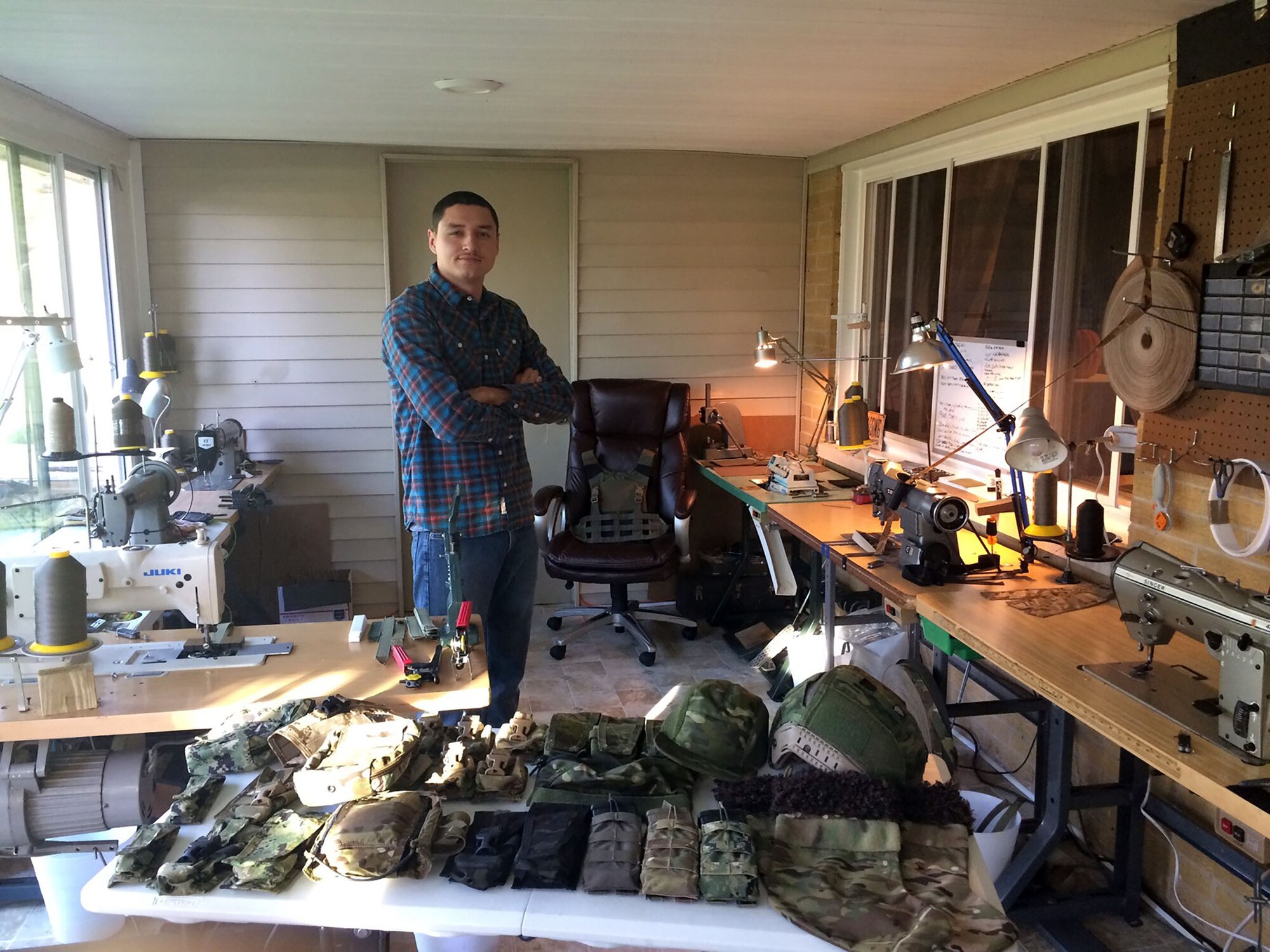 Airman First Class Devin Litton, 445th Operations Support Squadron Aircrew Flight Equipment shop, poses in his home workshop Oct. 20, 2017. Litton runs his own tactical gear business out of his garage.
