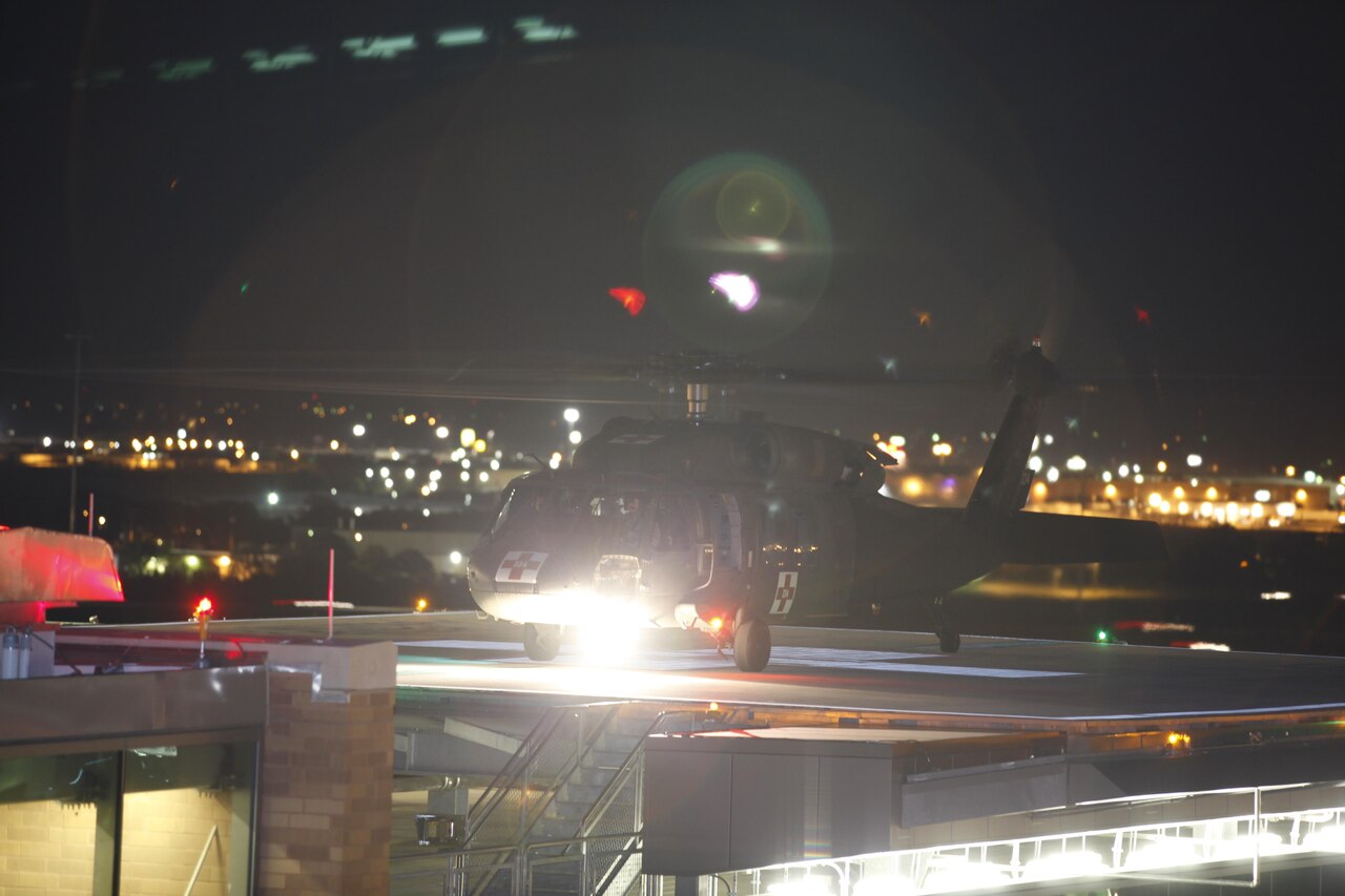 Helicopter lands at night on hospital's helipad.