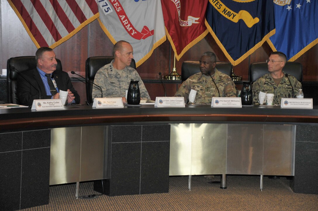 Senior leaders facing viewer at panel table