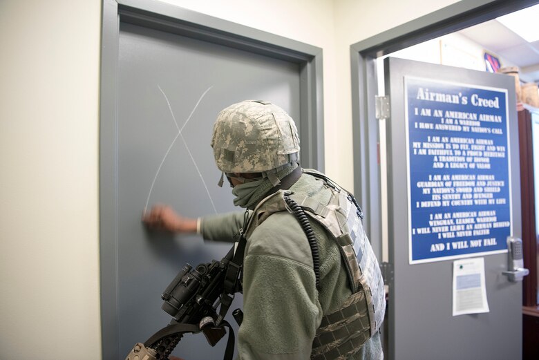 Senior Airman Rajesh Narain, 721st Security Forces Squadron, leader, marks a door during an active shooter exercise at Cheyenne Mountain Air Force Station, Colorado, Nov. 8, 2017. Security Forces marks doors during an emergency to indicate which rooms they have already checked. (U.S. Air Force photo by Steve Kotecki)