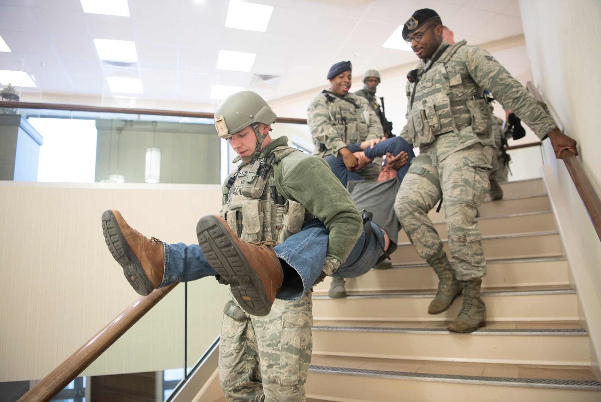 Three Airmen from the 721st Security Forces Squadron, carry an acting casualty down a flight of steps during an active shooter exercise at Cheyenne Mountain Air Force Station, Colorado, Nov. 8, 2017. Quickly moving wounded during an active shooter scenario is a priority for first responders and is often tested during the stressful situations designed to test Airmen. (U.S. Air Force photo by Steve Kotecki)
