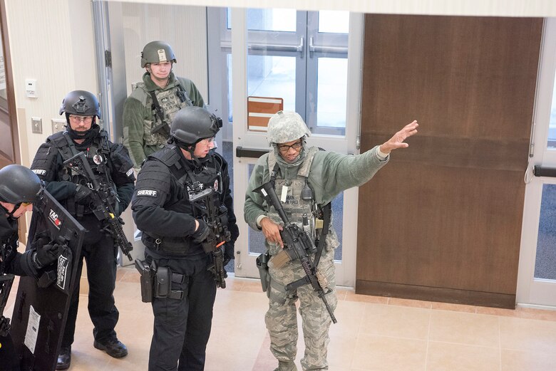 Senior Airman Rajesh Narain, 721st Security Forces Squadron, leader, directs members of the El Paso County Sheriff’s Office SWAT team to the location of the active shooter during an exercise at Cheyenne Mountain Air Force Station, Colorado, Nov. 8, 2017. Cheyenne Mountain AFS Security Forces and the El Paso County Sherriff’s department have a partnership agreement to coordinate training and response to crisis. (U.S. Air Force photo by Steve Kotecki)