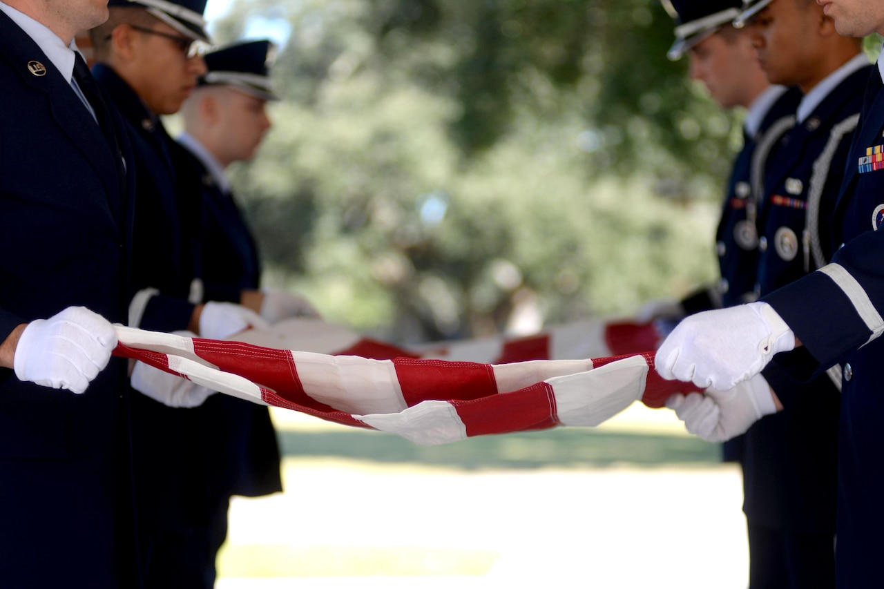 Airmen fold an American flag.