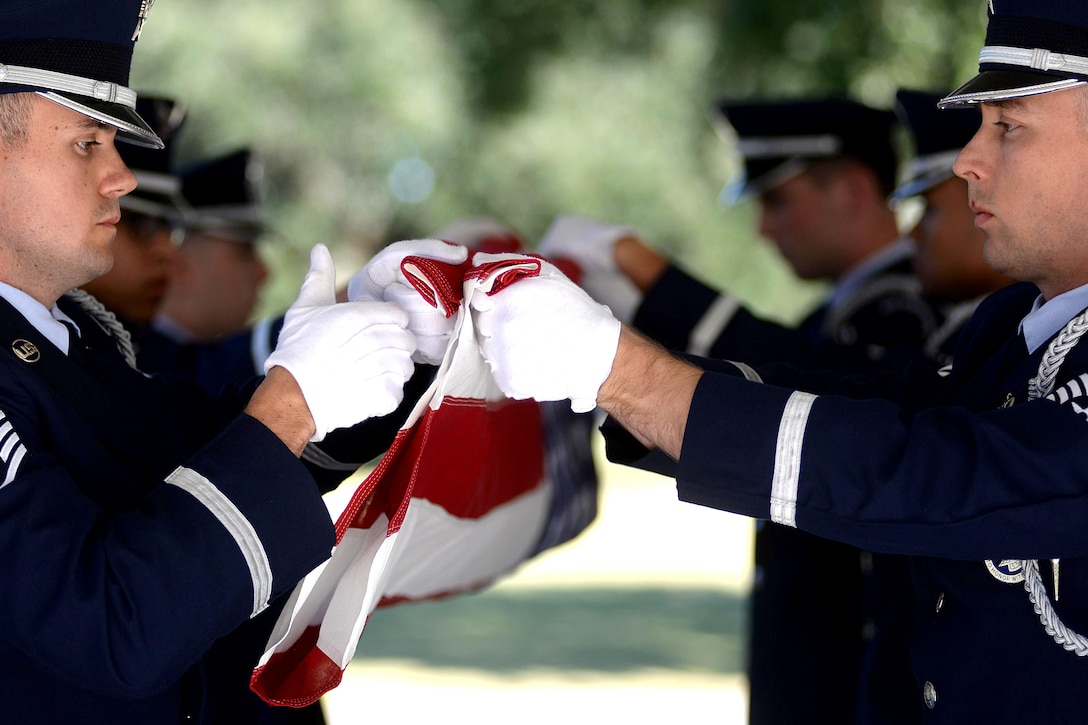 Airmen fold an American flag.