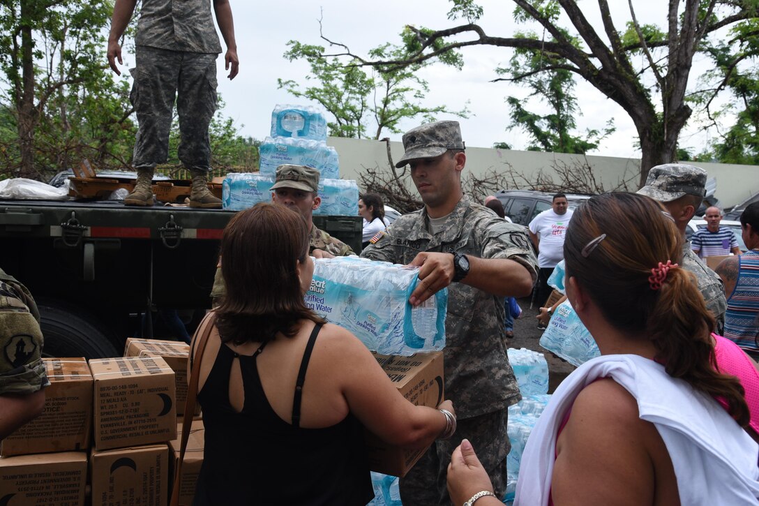 Former students distribute food and water at their local high school