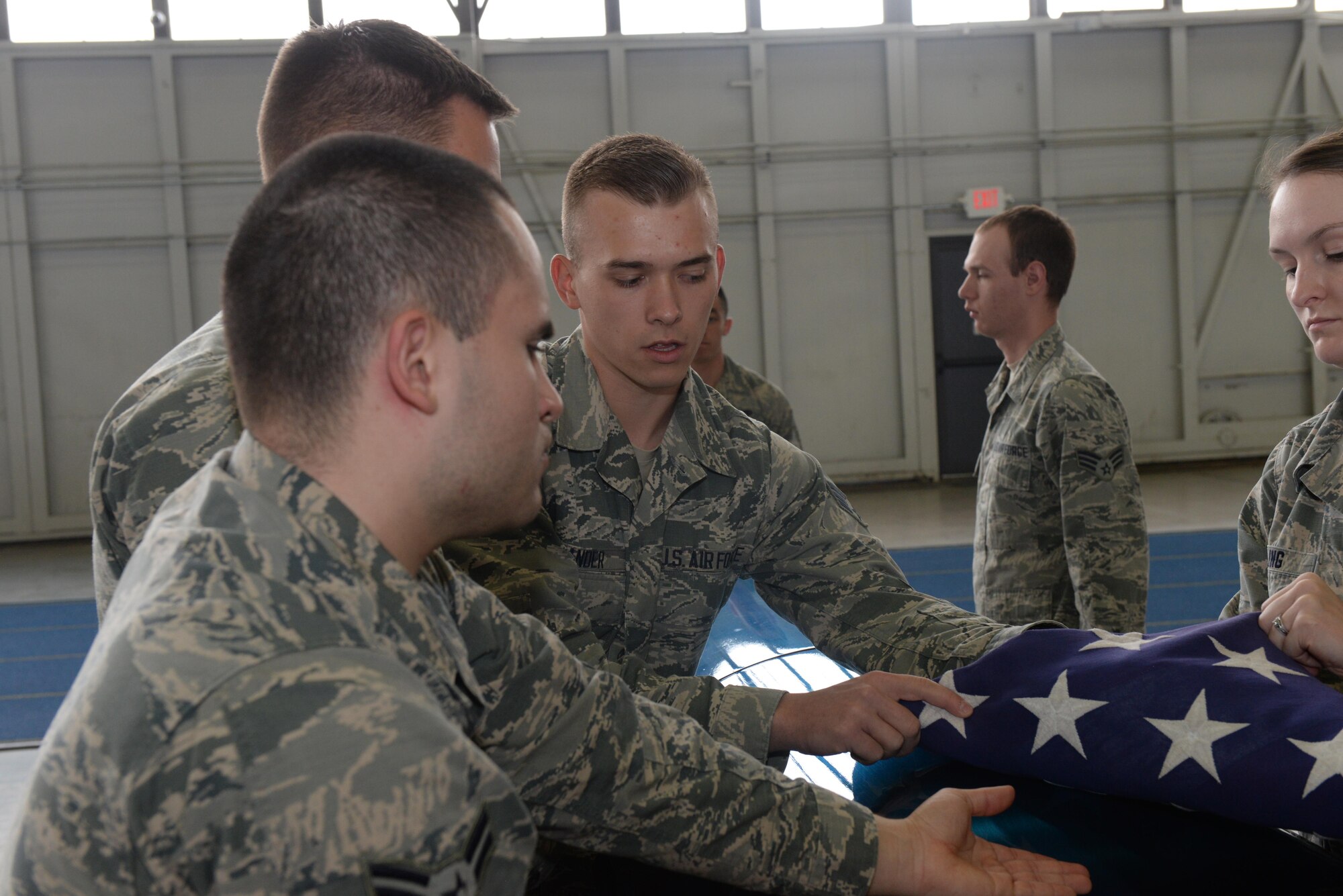 Senior Airman Andrew Zander, a formal training instructor assigned to the United States Air Force Honor Guard, Joint Base Anacostia-Bolling, DC, teaches Airmen with the Ellsworth Air Force Base, S.D., Honor Guard how to properly tuck in the flag during an honors sequence at the Pride Hangar on base, Oct. 26, 2017. The mobile training team had three different members: Senior Airman Andrew Zander was the pallbearer instructor, Senior Airman Anicia Davis was the firing party instructor and Senior Airman Amanda Skidmore was the colors team instructor. (U.S. Air Force photo by Airman Nicolas Z. Erwin)