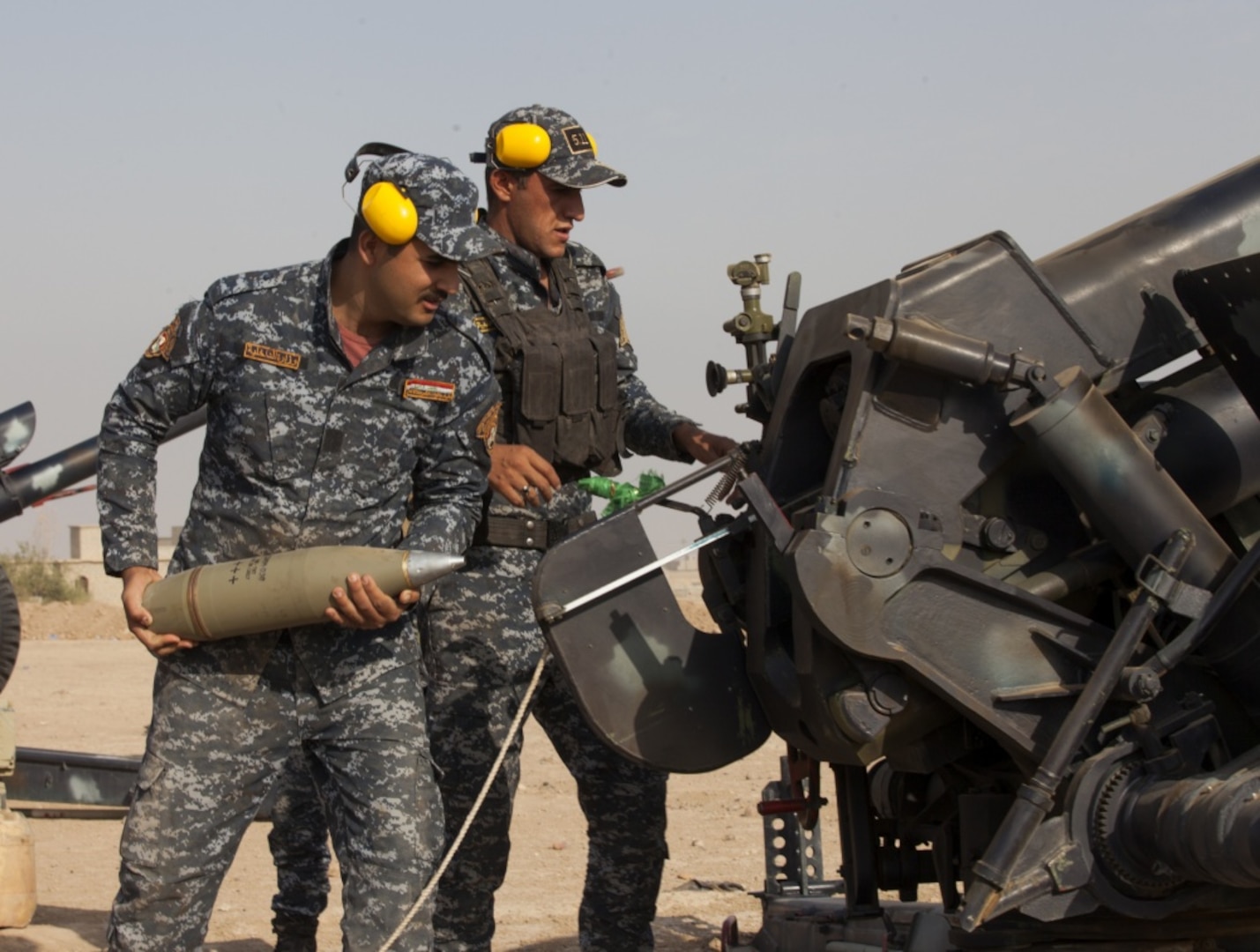 An Iraqi federal police officer loads artillery in support to the fight against the Islamic State of Iraq and Syria near Hawija, Iraq.