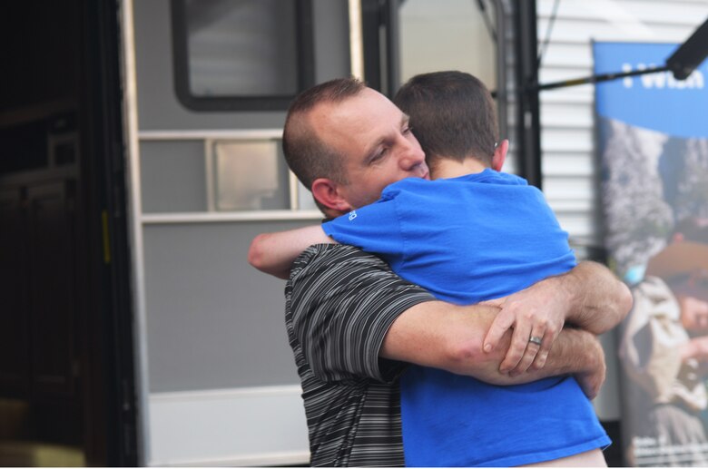 Capt. Steven Braddick, Weapons Station Engineering Element Chief with the 628th Air Base Wing Civil Engineer Squadron, hugs his son, Nathan James Braddick, during the unveiling of his gift from the Make-A-Wish Foundation at the Subaru of Charleston dealership on November 7, 2017. Nathan was born in 2001 with 32 genetic duplications and diagnosed with MECP2 duplication syndrome in 2010.