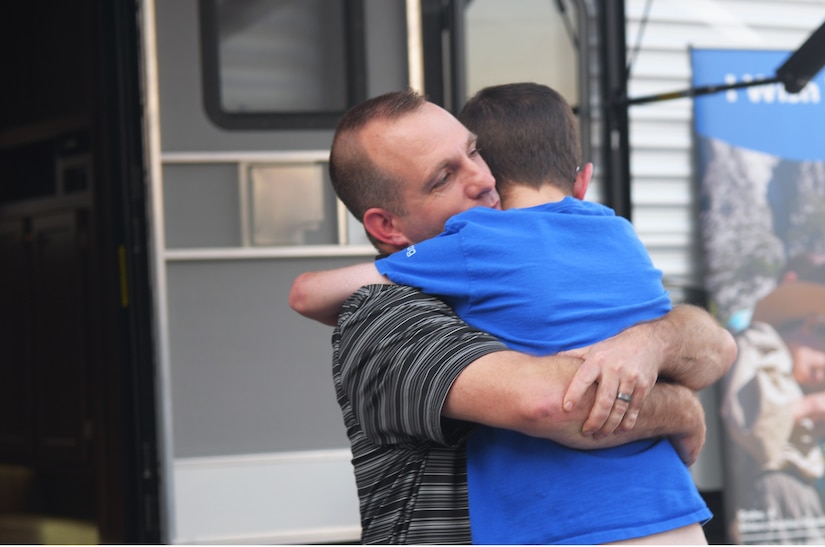 Capt. Steven Braddick, Weapons Station Engineering Element Chief with the 628th Air Base Wing Civil Engineer Squadron, hugs his son, Nathan James Braddick, during the unveiling of his gift from the Make-A-Wish Foundation at the Subaru of Charleston dealership on November 7, 2017. Nathan was born in 2001 with 32 genetic duplications and diagnosed with MECP2 duplication syndrome in 2010.