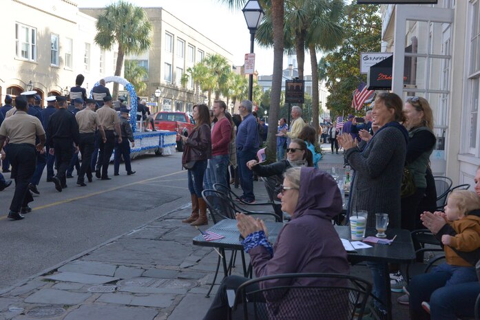 Spectators clap and wave American flags as service-members of JB Charleston participate in the annual Veterans Day parade in downtown Charleston, S.C. on November 11, 2017. Members of the U.S. Air Force, Navy and Coast Guard walked in a joint formation during the event.