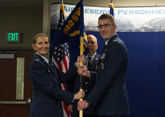 Col. Traci Kueker-Murphy, 310th Space Wing commander, passes the 710th Operations Group guidon to Col. Daniel Bourque during the activation ceremony of the group at Buckley AFB on Saturday, Nov. 4, 2017.