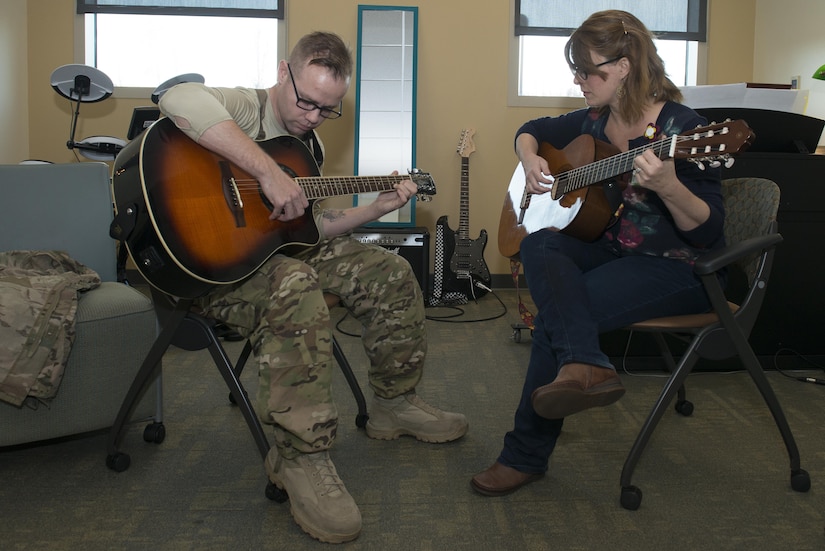 Army Staff Sgt. Sean Young, 2nd Battalion, 377th Parachute Field Artillery Regiment training room noncommissioned officer, strums the guitar during music therapy with Danielle Kalseth, 673d Medical Operations Squadron creative arts therapist/ music therapist, at Joint Base Elmendorf-Richardson, Alaska, Nov. 2, 2017. Music therapy sessions help rehabilitate patients with traumatic brain injury