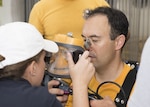 Naval Surface Warfare Center Panama City Division mechanical engineer Allie Pilcher helps Naval Diving Salvage and Training Center Commanding Officer Cmdr. Cameron Chen, USN, don the Diver Augmented Vision Display (DAVD) full-face mask during in-water testing