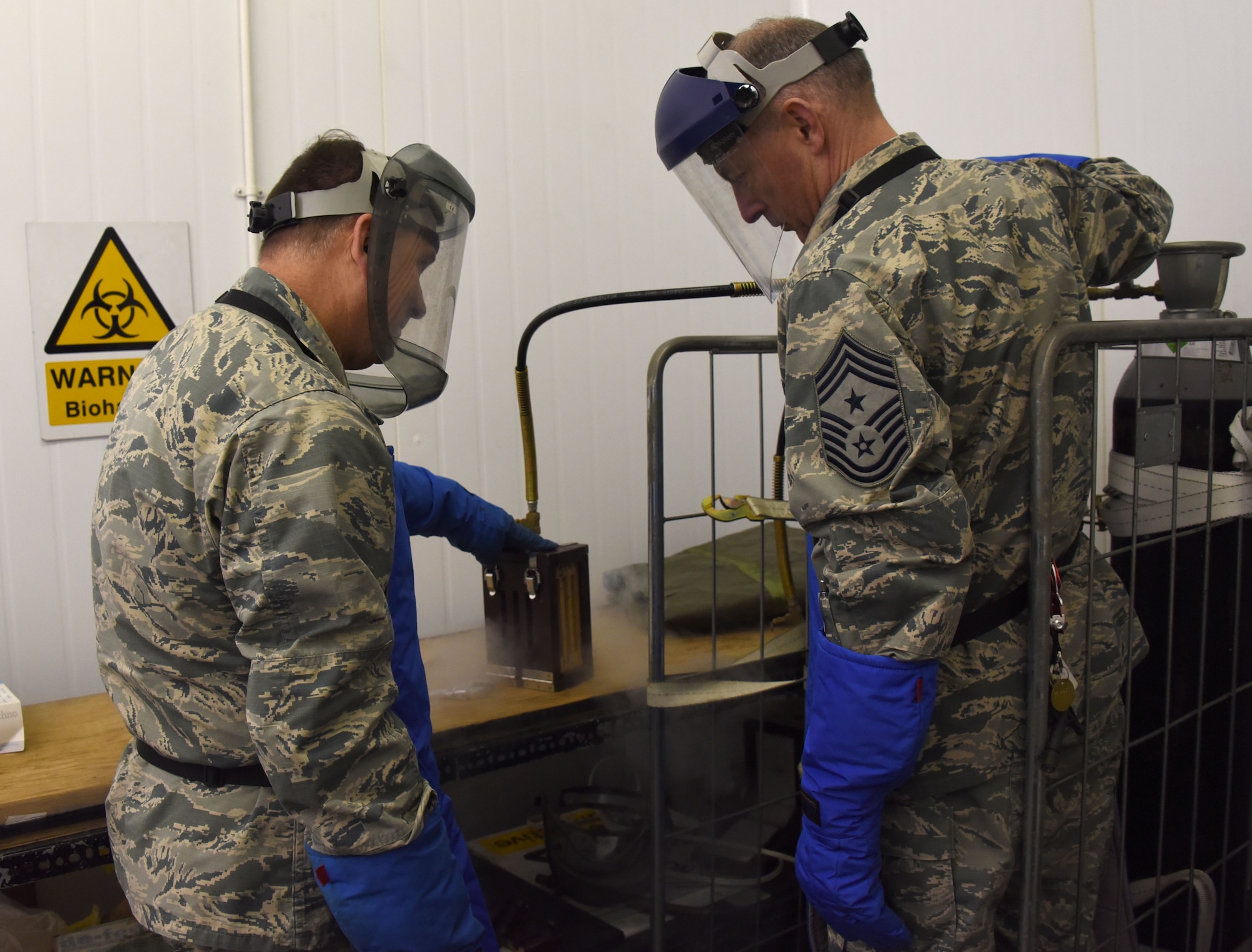 Maj. gen. Christopher Bence (left), commander, USAF Expeditionary Center and Command Chief Master Sgt. Larry Williams, USAF EC command chief, make dry ice while visiting Airmen assigned to the 727th Air Mobility Squadron at RAF Mildenhall, U.K., Nov. 8, 20017. Bence and Williams along with the 521st Air Mobility Operations Wing leadership team visited six squadrons of the 521st AMOW at Ramstein AB and Spangdahlem AB, Germany, Aviano AB, Italy and RAF Mildenhall, U.K. (U.S. Air Force photo by Tech. Sgt. Jamie Powell)