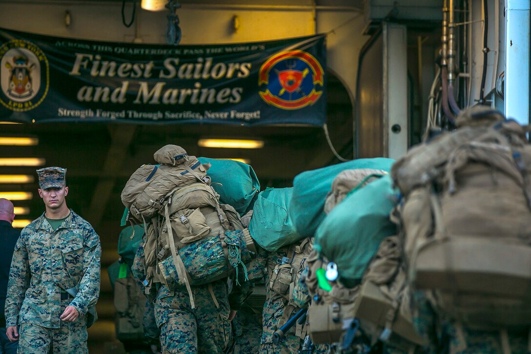 Marines and sailors embark aboard the amphibious transport dock USS New York.