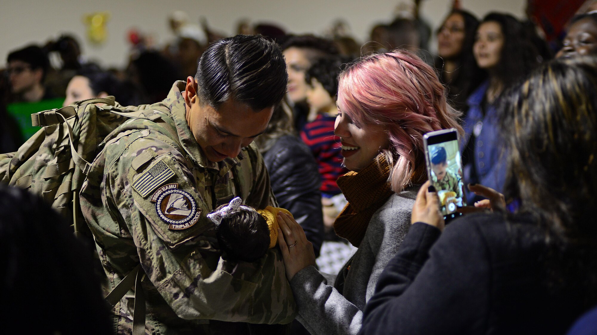 Senior Airman David Ojeda, 31st Maintenance Group crew member, meets his infant child for the first time moments after returning to Aviano Air Base, Italy, Nov. 6, 2017, from a deployment at Bagram Air Field, Afghanistan. Ojeda is one of 380 Airmen and who were deployed from Aviano Air Base to support Operation Freedom’s Sentinel. (U.S. Air Force photo by Airman 1st Class Ryan Brooks)