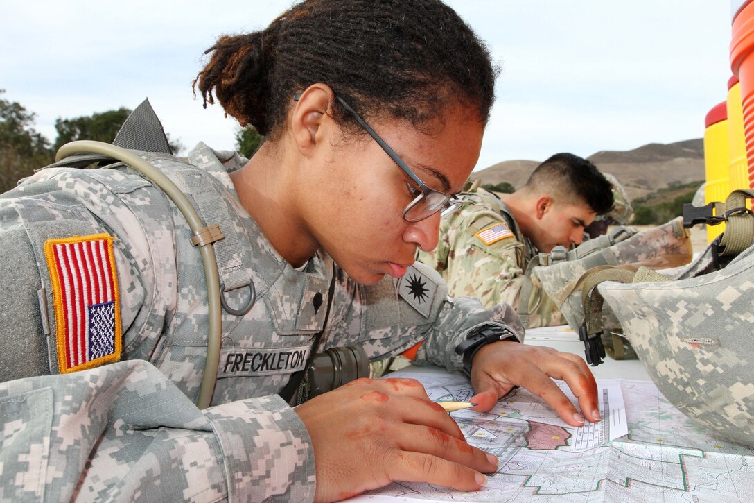Army Spc. Emefa Freckleton uses a protractor and map to plot five coordinates during the day land navigation.