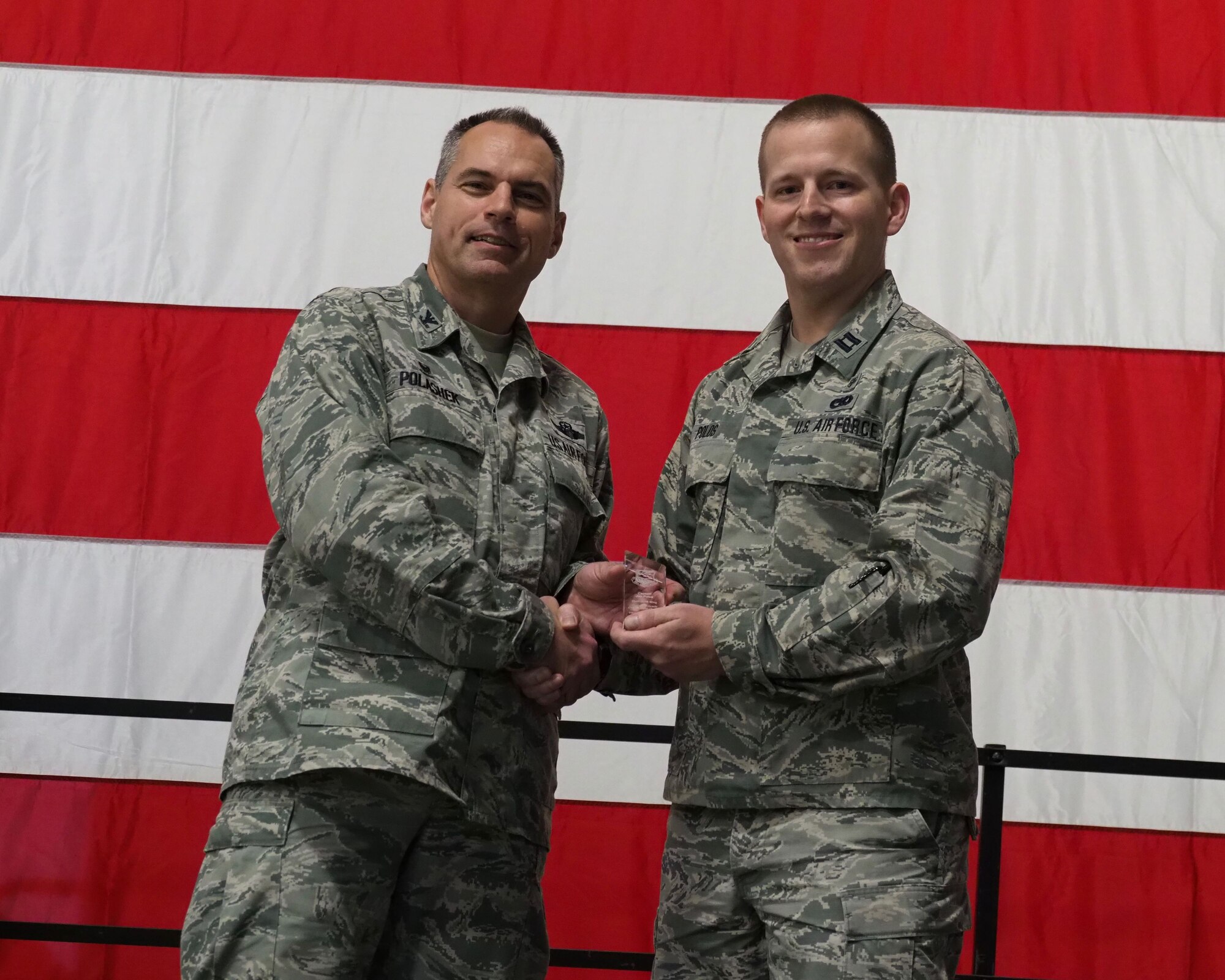 Col. Tony Polashek, 934th Airlift Wing commander, recognizes Capt. Jon Polos as the Company Grade Officer of the Quarter at the Commander's Call Nov. 4. (Air Force Photo/Paul Zadach)