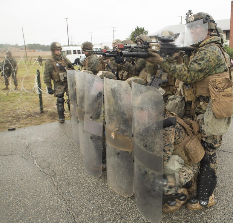 Marines from 4th platoon, Charlie Co., Fleet Anti-terrorism Security Team, U.S. Marine Corps Security Forces Regiment, form a riot-control formation in response to a simulated hostile crowd during a diplomatic security and embassy reinforcement training exercise at Joint Expeditionary Base Ft. Story, Virginia Beach, Va., Nov. 8. FAST Marines rotated between gate security, response team and various other armed positions during the three-day exercise in order to practice skills required for real-world embassy missions. (Official U.S. Marine Corps photo by Chris Jones/Released)