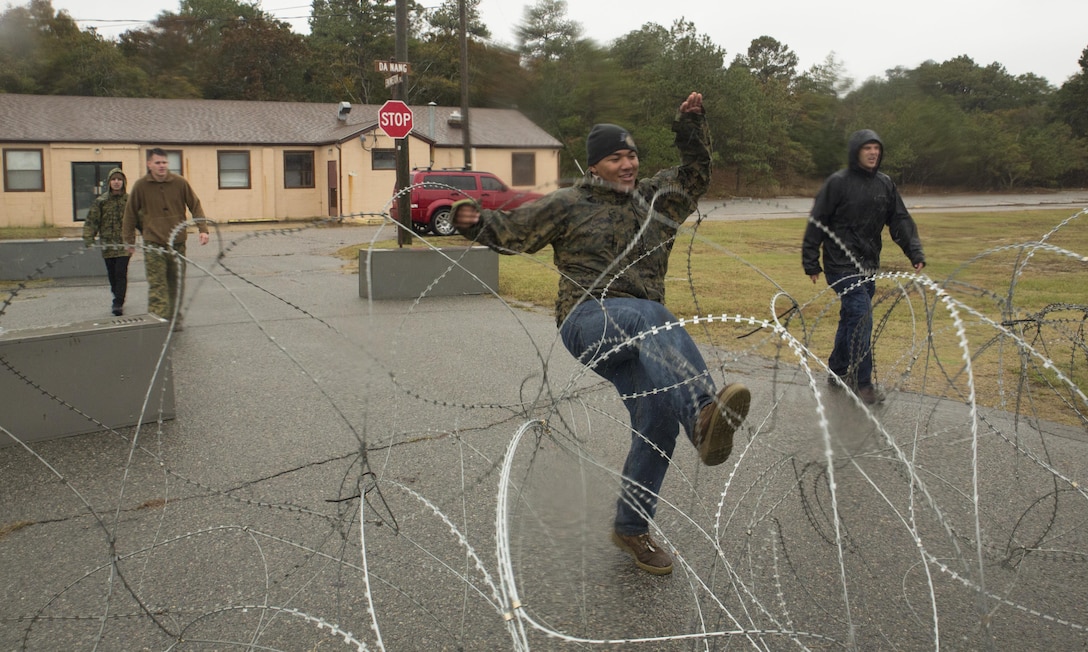 Marines from U.S. Marine Corps Forces Command, and 4th platoon, Charlie Co., Fleet Anti-terrorism Security Team, U.S. Marine Corps Security Forces Regiment, act as an opposition force during a diplomatic security and embassy reinforcement training exercise at Joint Expeditionary Base Ft. Story, Virginia Beach, Va., Nov. 8. MARFORCOM Marines portrayed a hostile force in order for the embassy team to practice proper quick response techniques. (Official U.S. Marine Corps photo by Chris Jones/Released)