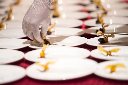 A chef sets fruit on white plates